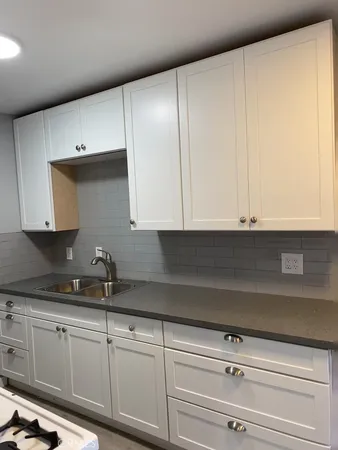 a kitchen with granite countertop white cabinets and white appliances