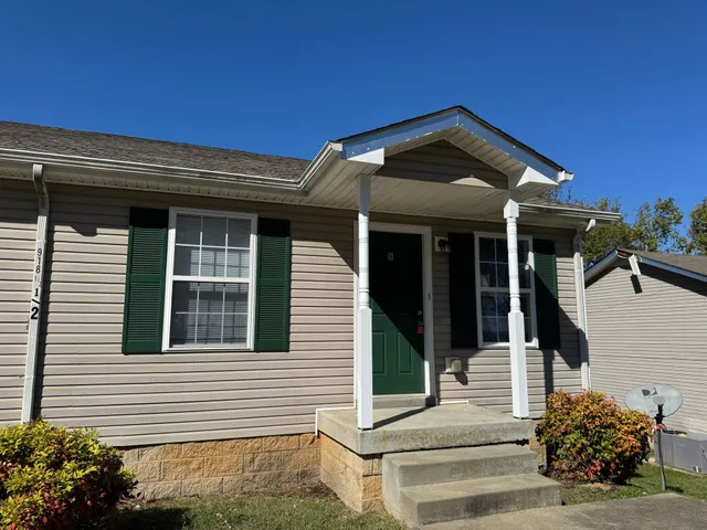 a view of a house with entryway and a yard