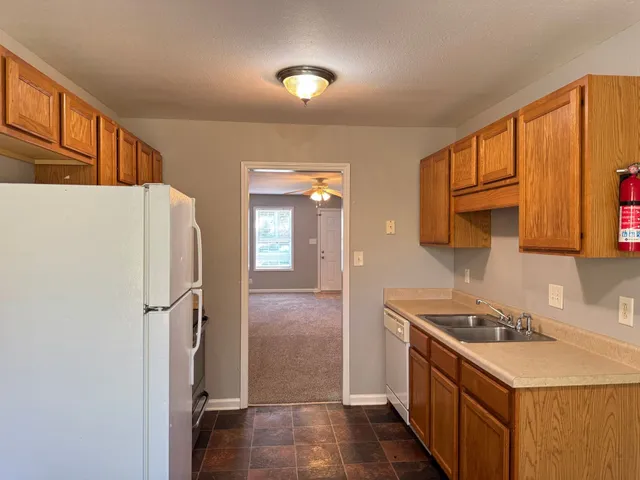 a kitchen with stainless steel appliances a refrigerator a sink a stove and cabinets