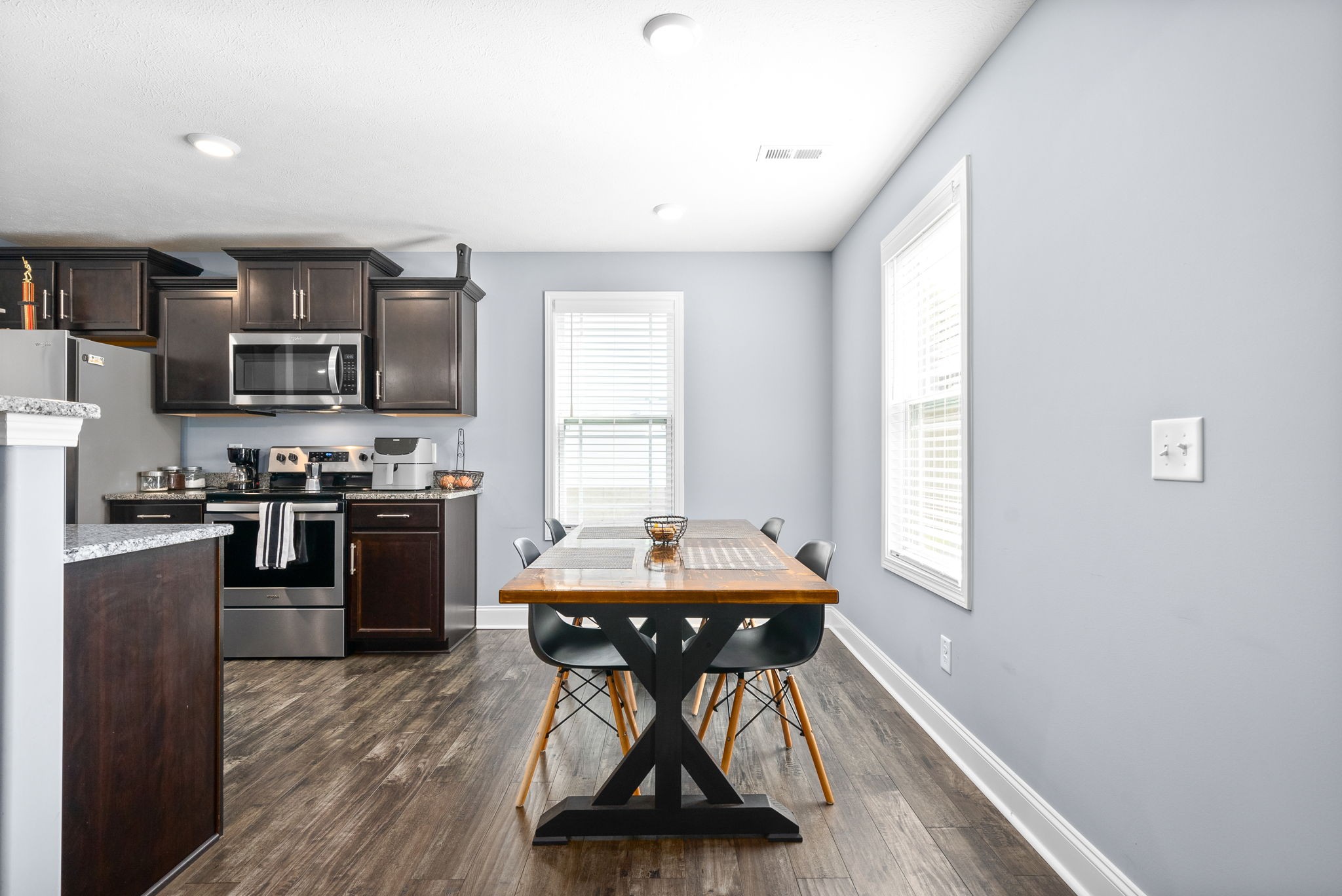 1807 Rains Road Clarksville, TN 37042 - Photo 11 of 39 a kitchen with stainless steel appliances a stove a refrigerator a sink a dining table and chairs with wooden floor