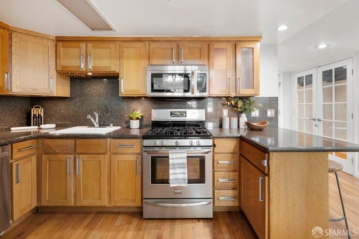 1578 Indiana Street, Unit 8 San Francisco, CA 94107 - Photo 12 of 36 a kitchen with stainless steel appliances granite countertop a stove a sink and a microwave