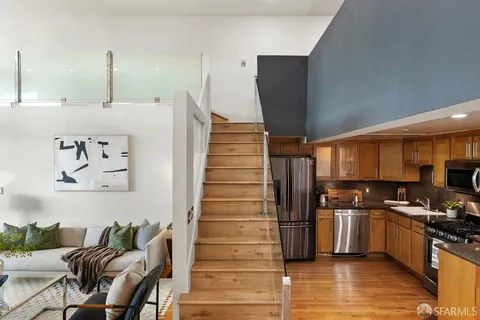 a kitchen with granite countertop a refrigerator and a stove top oven