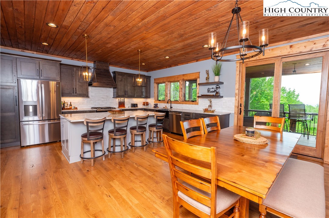 165 Eagle Pass Banner Elk, NC 28604 - Photo 18 of 41 a room with stainless steel appliances kitchen island granite countertop a table chairs and a chandelier