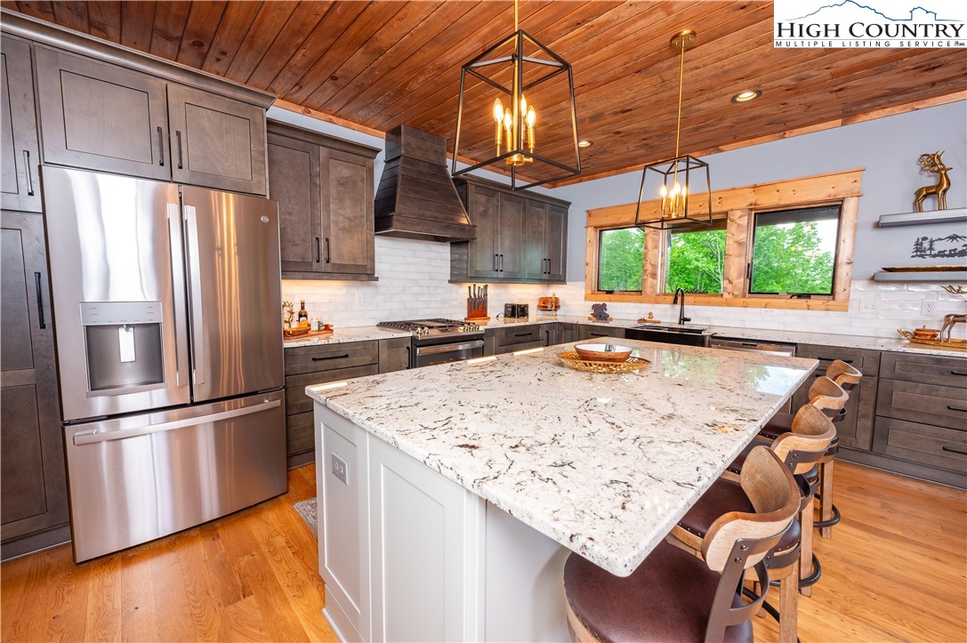 165 Eagle Pass Banner Elk, NC 28604 - Photo 19 of 41 a kitchen with stainless steel appliances granite countertop a refrigerator a sink dishwasher a stove and a refrigerator with wooden floor