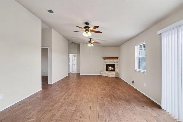 a view of an empty room with a ceiling fan and a window
