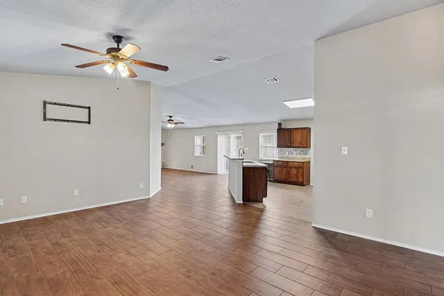 a view of kitchen with a sink wooden cabinet and a refrigerator