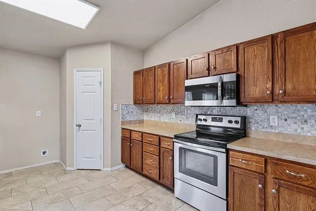 a kitchen with stainless steel appliances granite countertop a stove a microwave and cabinets