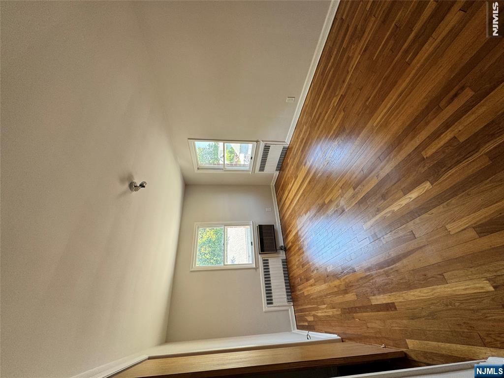251 Fort Lee Road, Unit D Teaneck, NJ 07666 - Photo 11 of 14 an empty room with wooden floor and windows