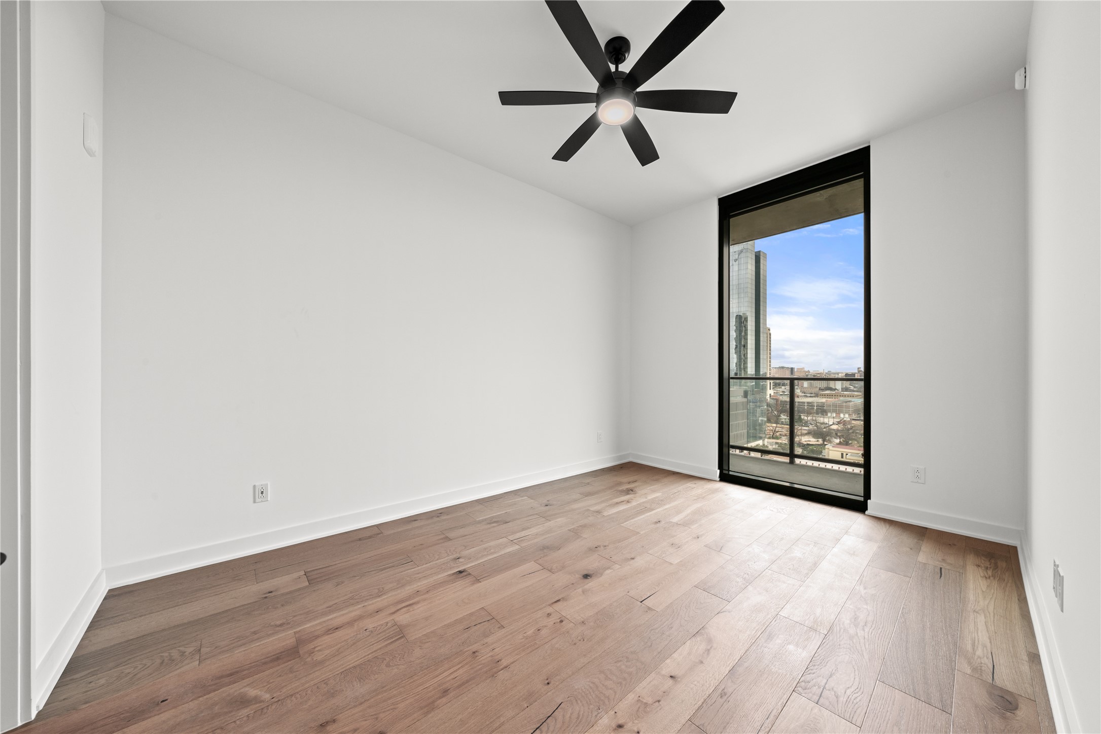 84 East Avenue, Unit 2003 Austin, TX 78701 - Photo 9 of 29 Representative Photo. Secondary Bedroom with wood flooring, floor to ceiling window
