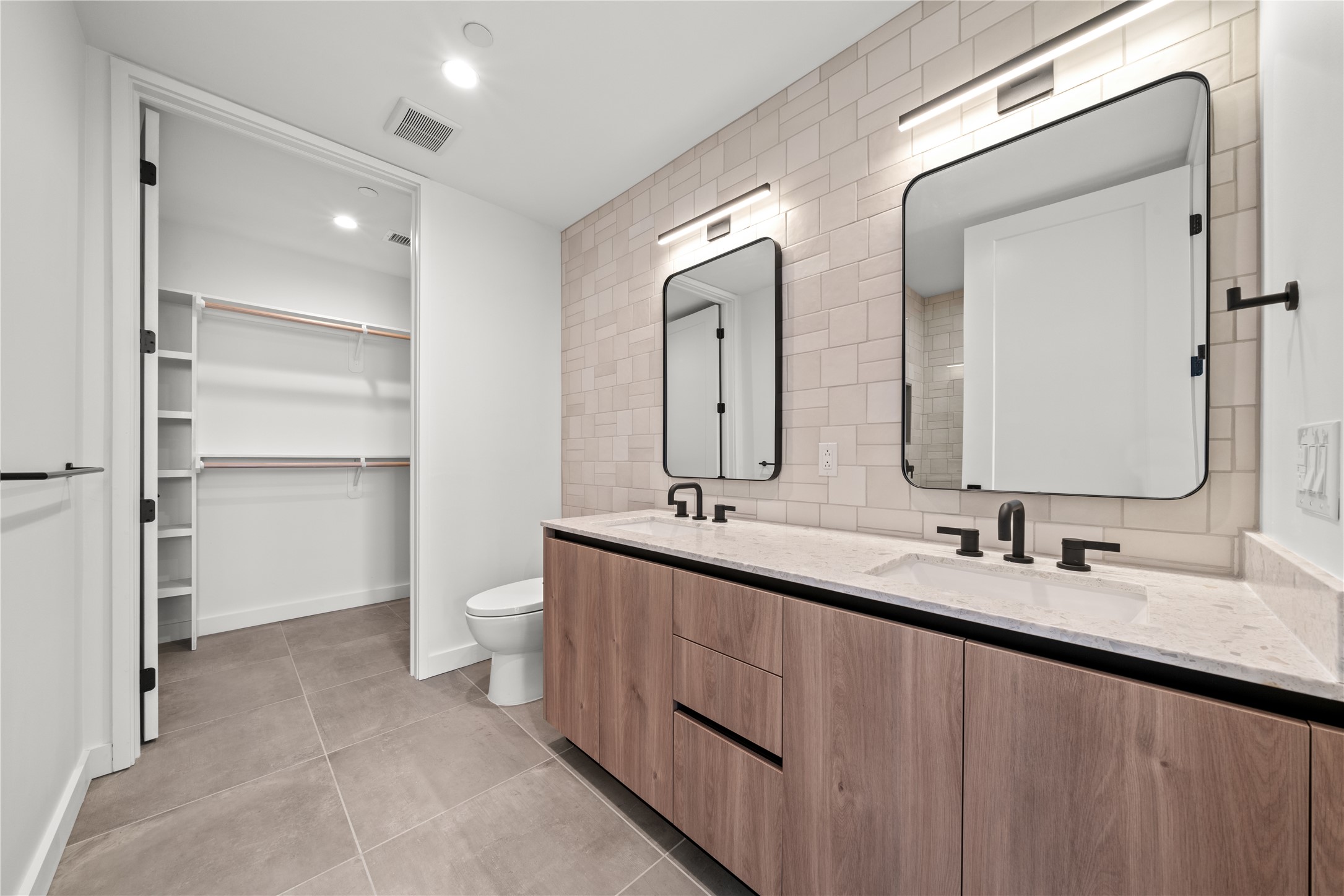 84 East Avenue, Unit 2003 Austin, TX 78701 - Photo 6 of 29 Representative Photo. Primary Bathroom with double vanity, tile patterned floors and backsplash, walk in closet