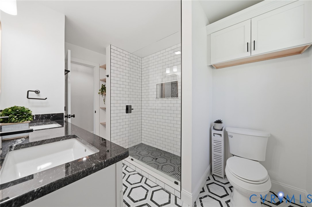 1100 Hollins Road Henrico, VA 23229 - Photo 21 of 38 a bathroom with a granite countertop toilet a sink and a mirror