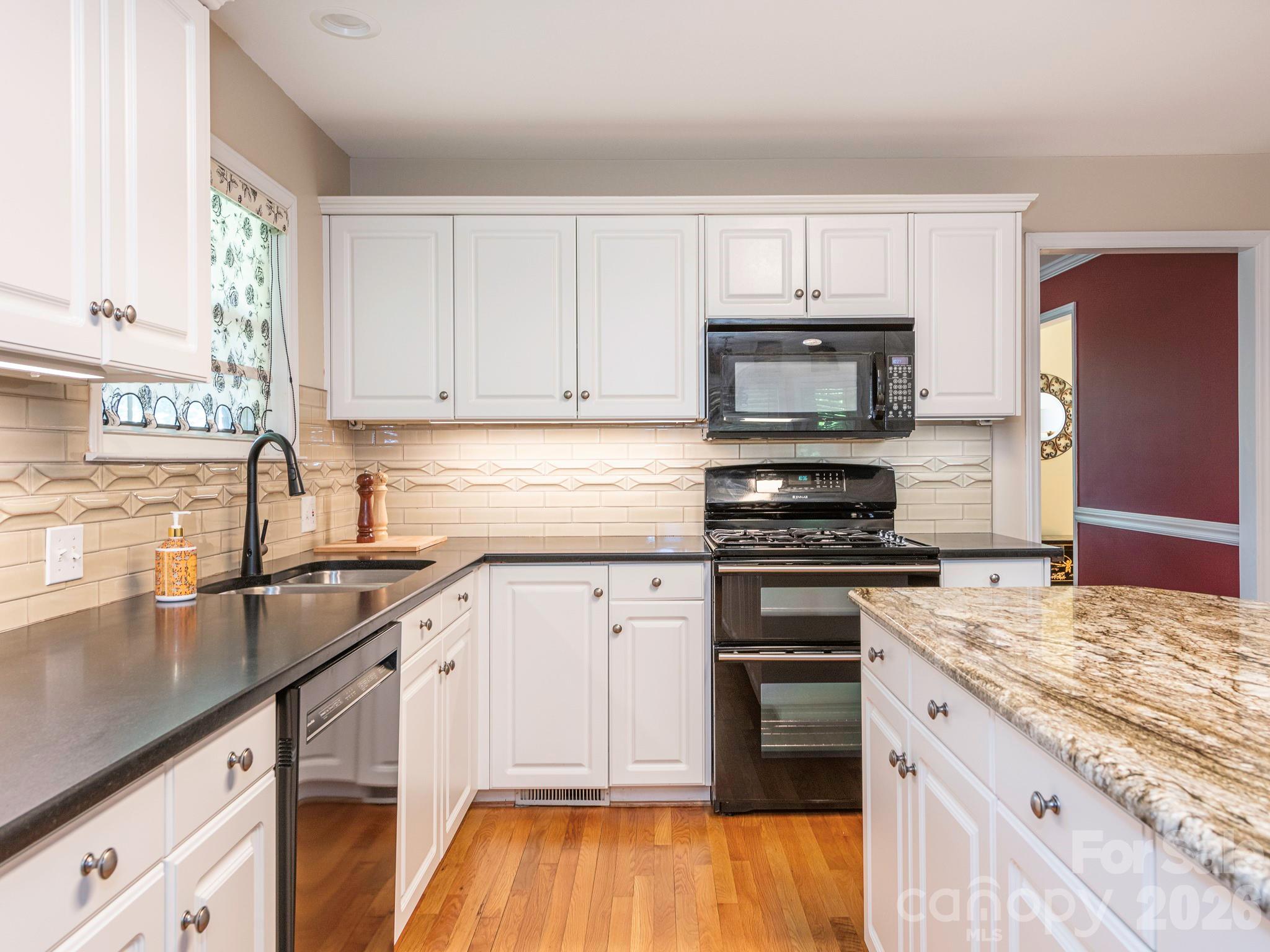 4440 Hucks Road Charlotte, NC 28269 - Photo 13 of 45 a kitchen with granite countertop a stove sink and cabinets