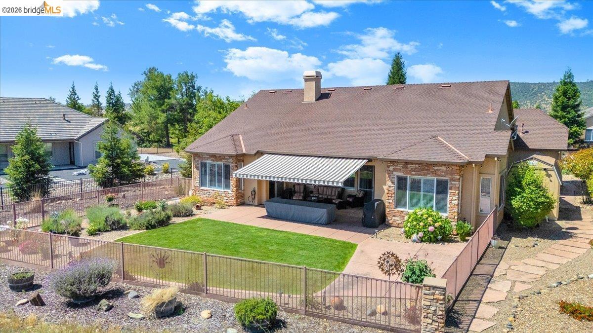 158 Rock Ridge Lane Copperopolis, CA 95228 - Photo 46 of 72 Rear exterior featuring a stone and stucco finish, brown shingle roof, and an extended concrete patio