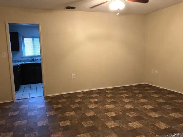 an empty room with wooden floor cabinet and mirror