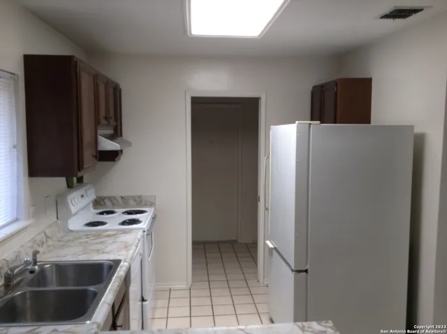a kitchen with a refrigerator sink and cabinets