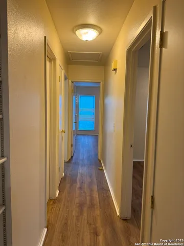 a view of a hallway with wooden floor