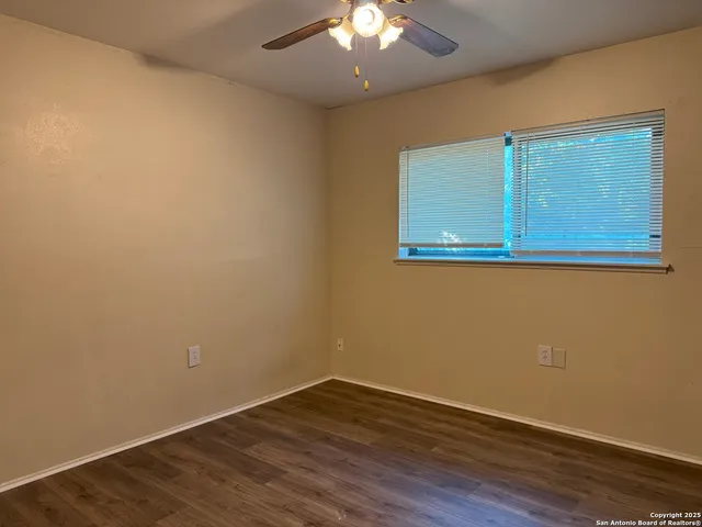 a view of a livingroom with wooden floor and a ceiling fan