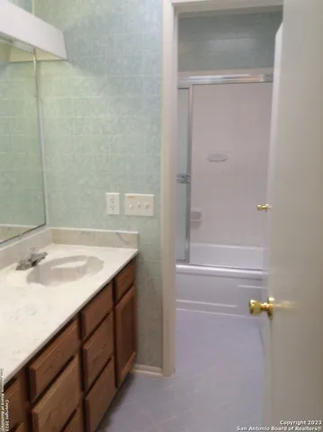 a bathroom with a granite countertop sink and a mirror