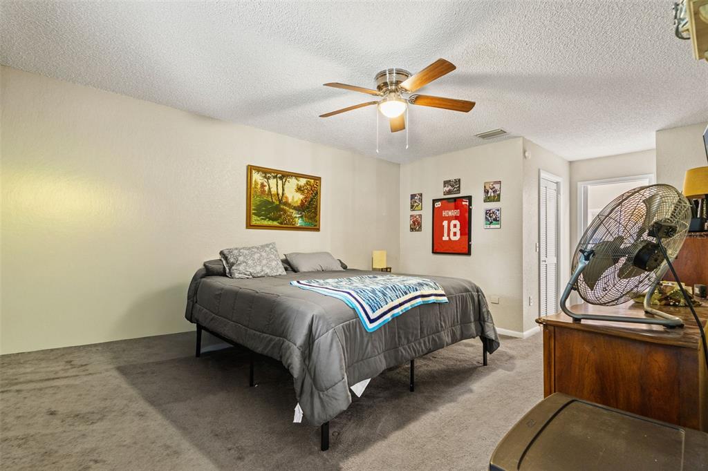 12292 Ronald Street Spring Hill, FL 34609 - Photo 11 of 18 a bedroom with a bed and ceiling fan