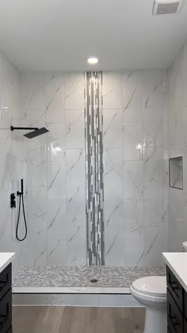 a bathroom with a granite countertop sink a toilet and shower