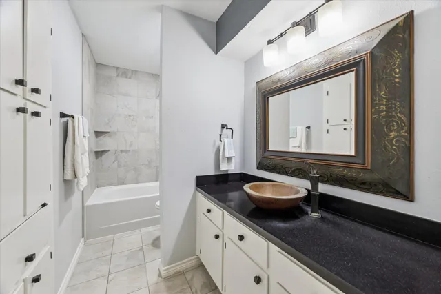 a bathroom with a granite countertop sink toilet a mirror and bathtub