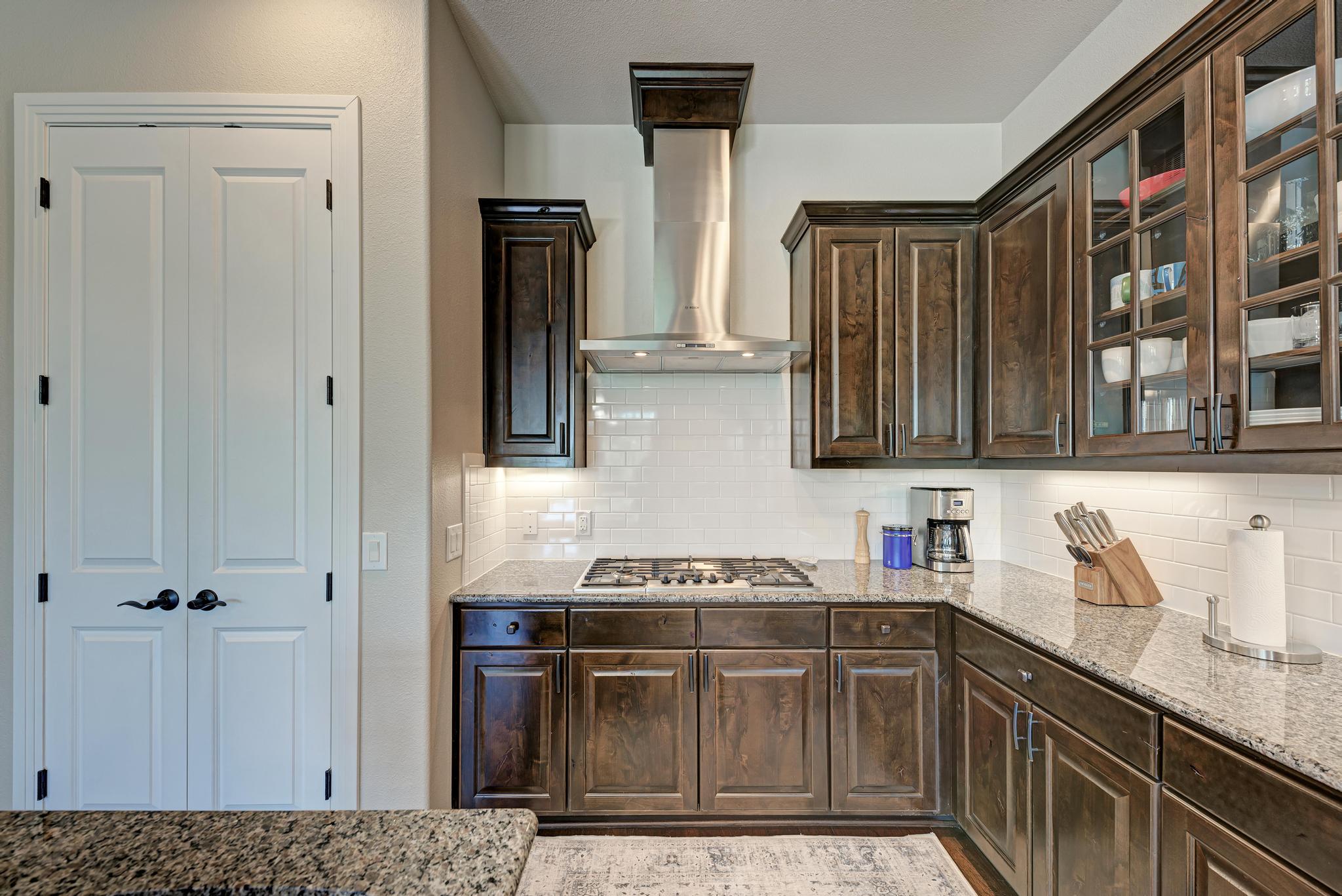 2601 North Quinlan Park Road, Unit 506 Austin, TX 78732 - Photo 19 of 39 Culinary adventures await in this kitchen featuring abundant wood cabinetry and polished granite countertops.