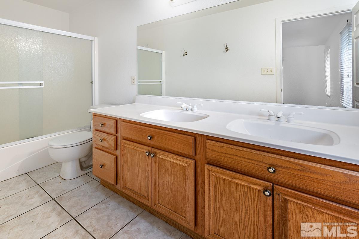 1390 Washington Street Reno, NV 89503 - Photo 11 of 16 a spacious bathroom with a granite countertop sink a toilet and a mirror