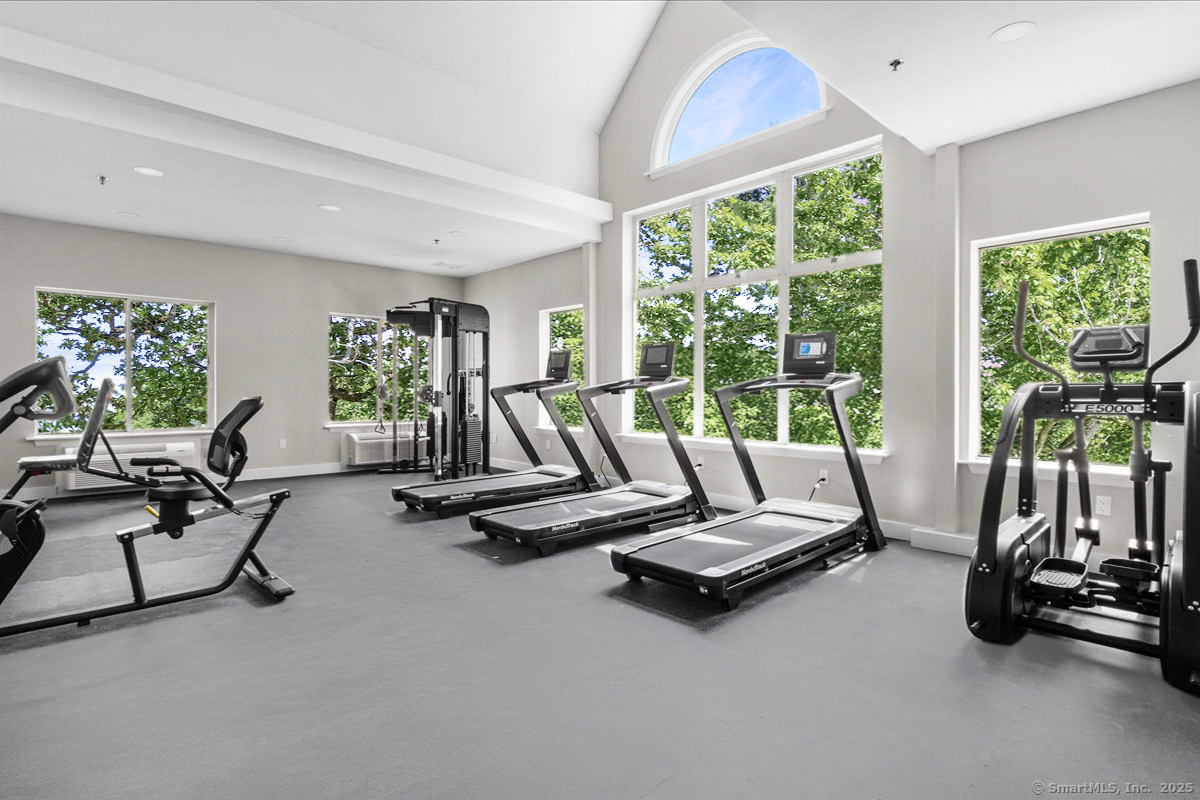 135 Gold Star Highway, Unit 412 Groton, CT 06340 - Photo 5 of 15 a view of a room with gym equipment and floor to ceiling window