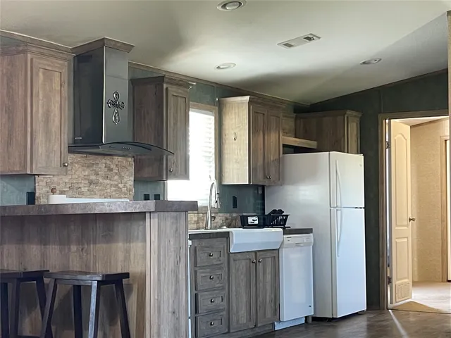 a kitchen with stainless steel appliances granite countertop a refrigerator sink and cabinets
