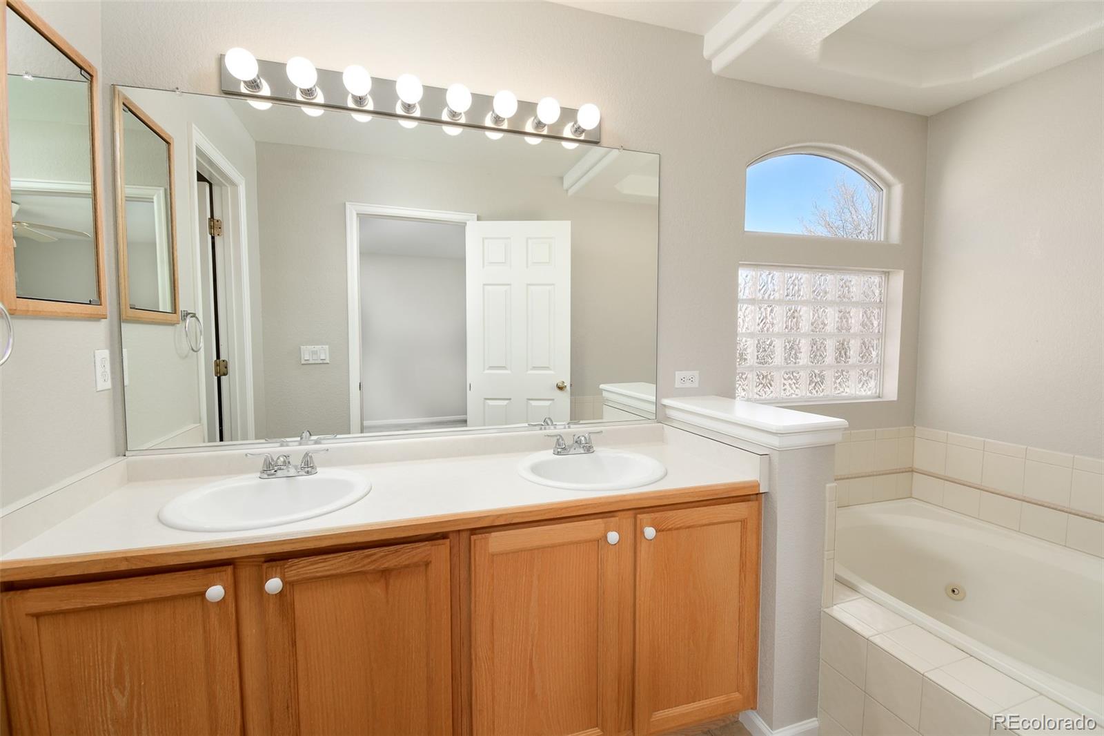 9265 Roadrunner Street Highlands Ranch, CO 80129 - Photo 16 of 28 a bathroom with a sink double vanity and a bathtub