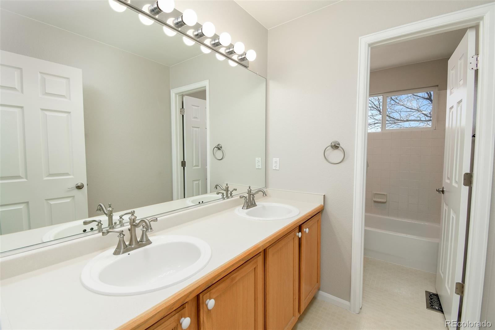 9265 Roadrunner Street Highlands Ranch, CO 80129 - Photo 22 of 28 a bathroom with a sink double vanity and a mirror