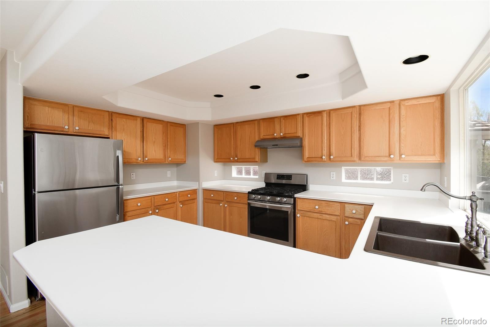 9265 Roadrunner Street Highlands Ranch, CO 80129 - Photo 8 of 28 a kitchen with stainless steel appliances a stove refrigerator sink and cabinets