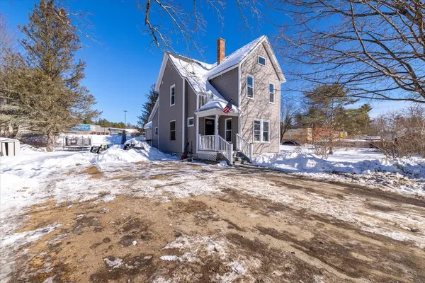 a view of a house with a yard covered in snow
