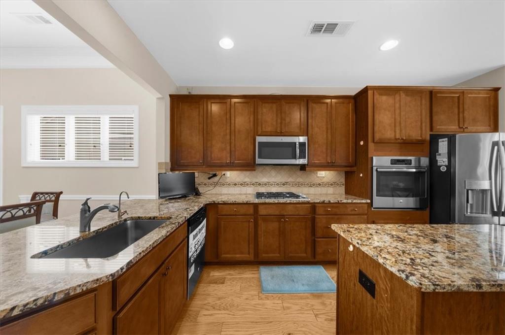 3739 Golden Leaf Point Southwest Gainesville, GA 30504 - Photo 16 of 60 a kitchen with stainless steel appliances granite countertop a sink stove microwave and refrigerator