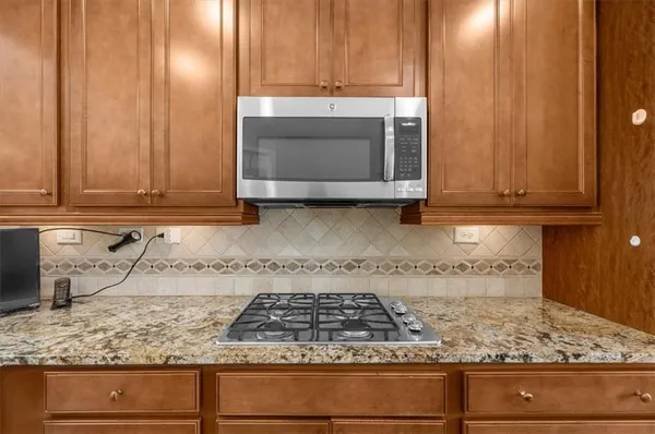 a kitchen with granite countertop stainless steel appliances white cabinets and a sink