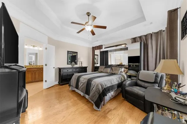 a spacious bedroom with a bed window and a flat screen tv