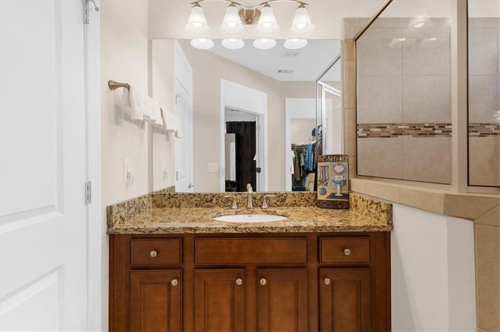 3739 Golden Leaf Point Southwest Gainesville, GA 30504 - Photo 24 of 60 a bathroom with a granite countertop sink a large mirror and a shower