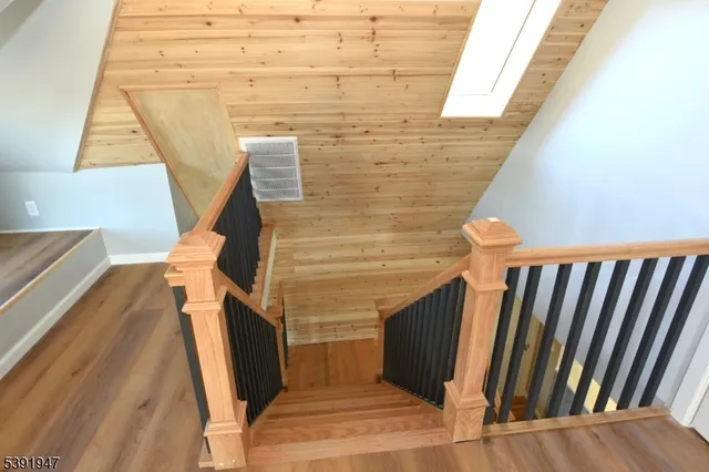 a view of a hallway with wooden floor and stairs