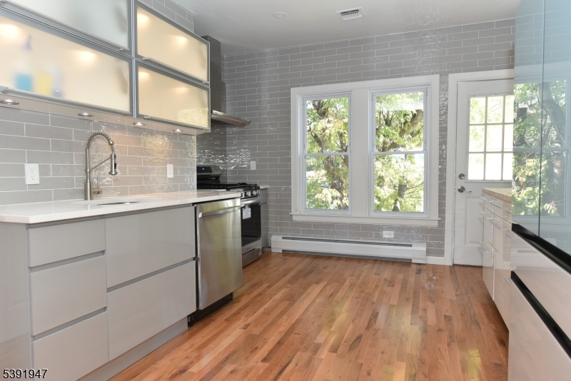 454 Park Avenue Rutherford, NJ 07070 - Photo 8 of 27 a kitchen with a sink a wooden floor and a large window
