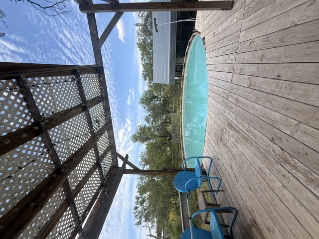 221 Winding Way Road Marble Falls, TX 78654 - Photo 11 of 12 A spacious wood deck overlooks a serene swimming pool, ideal for relaxation and entertaining. This above ground pool is a great, quiet place to cool off in the Texas Summertime!