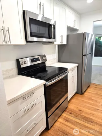a kitchen with stainless steel appliances a stove microwave and refrigerator