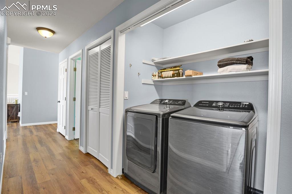3805 Curtis Road Peyton, CO 80831 - Photo 16 of 36 a view of washer and dryer with wooden floor