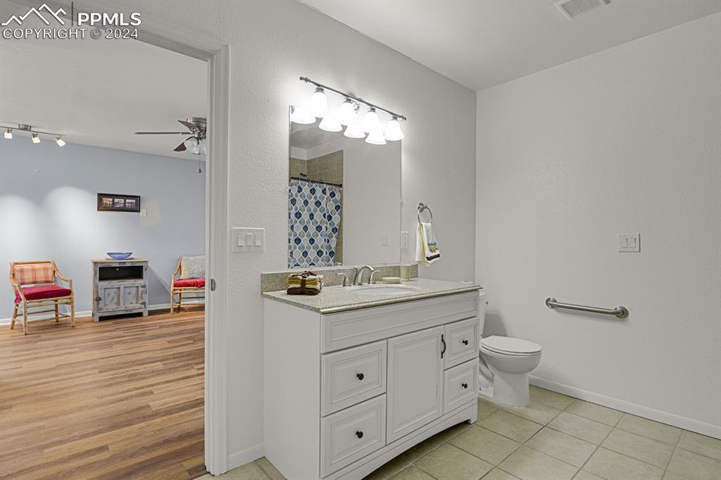 3805 Curtis Road Peyton, CO 80831 - Photo 26 of 36 a bathroom with a toilet a sink and mirror