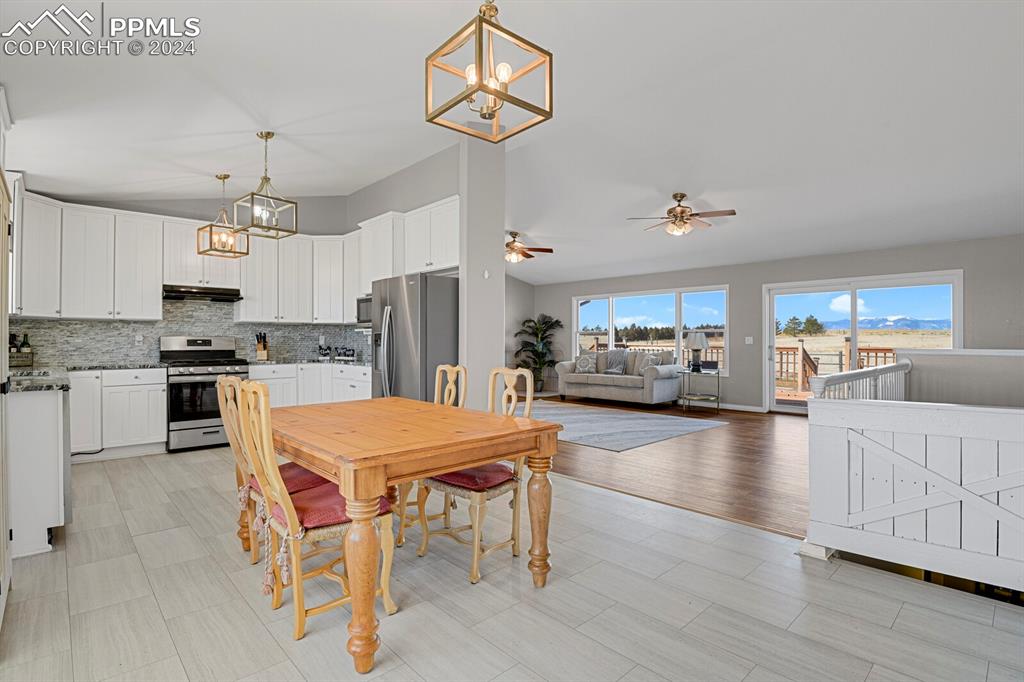 3805 Curtis Road Peyton, CO 80831 - Photo 7 of 36 a kitchen with a refrigerator a stove cabinets dining table and chairs