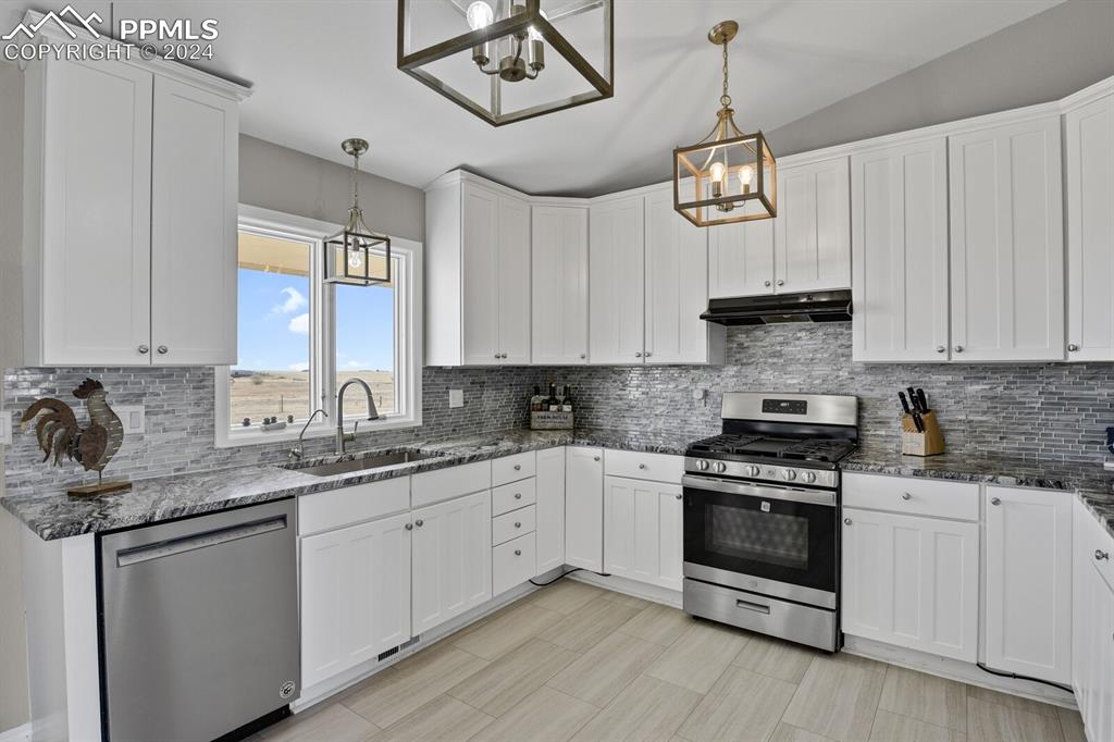 3805 Curtis Road Peyton, CO 80831 - Photo 8 of 36 a kitchen with stainless steel appliances a stove sink and cabinets