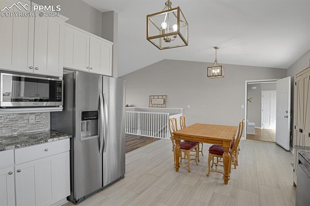 3805 Curtis Road Peyton, CO 80831 - Photo 10 of 36 a kitchen with stainless steel appliances a dining table chairs and refrigerator