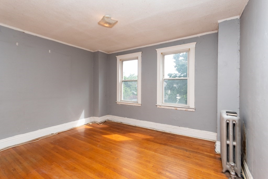 88 Winthrop Street Boston, MA 02119 - Photo 13 of 20 a view of an empty room with wooden floor and a window