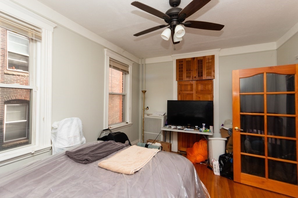 88 Winthrop Street Boston, MA 02119 - Photo 6 of 20 a bedroom with furniture and a flat screen tv