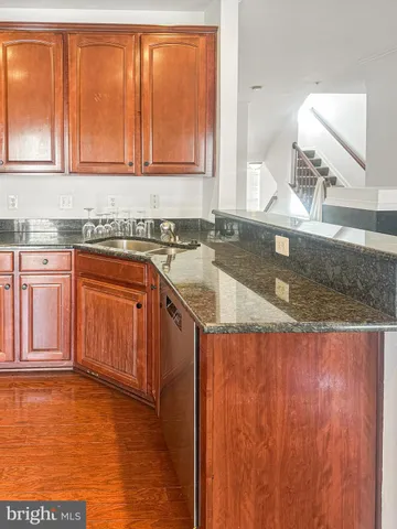 a kitchen with granite countertop a sink window and cabinets