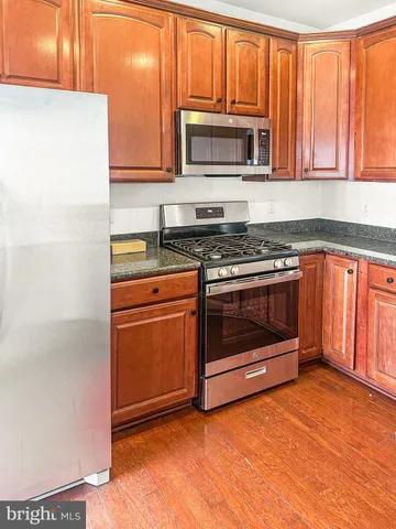a kitchen with granite countertop a stove top oven microwave and cabinets